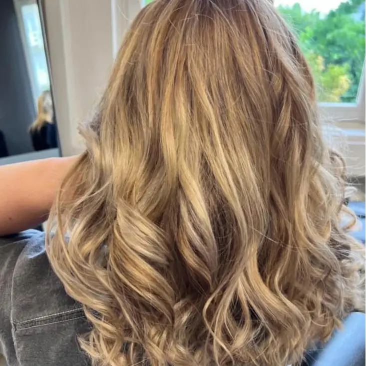 insta4 Frau mit langem, gewelltem blondem Haar bei Friseur Villa Reichardt.